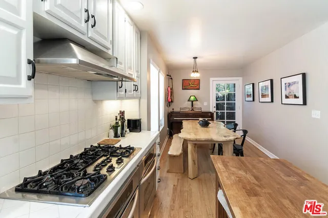 a kitchen with a stove and white cabinets
