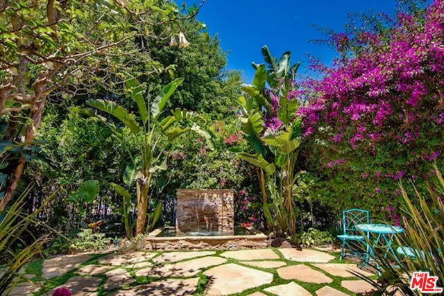 a flower plants and trees in front of a house
