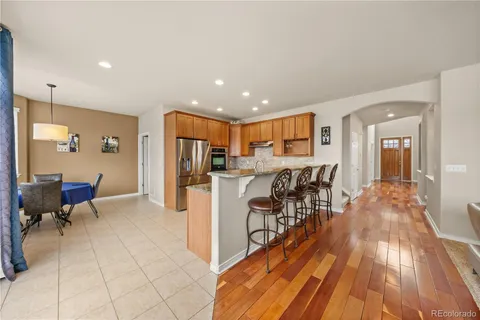 a view of a kitchen with kitchen island stainless steel appliances refrigerator stove microwave and cabinets