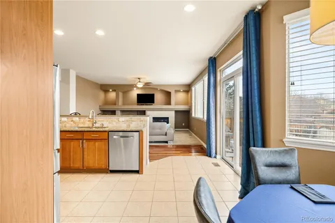 a open kitchen with stainless steel appliances granite countertop a stove top oven a sink a dining table and chairs