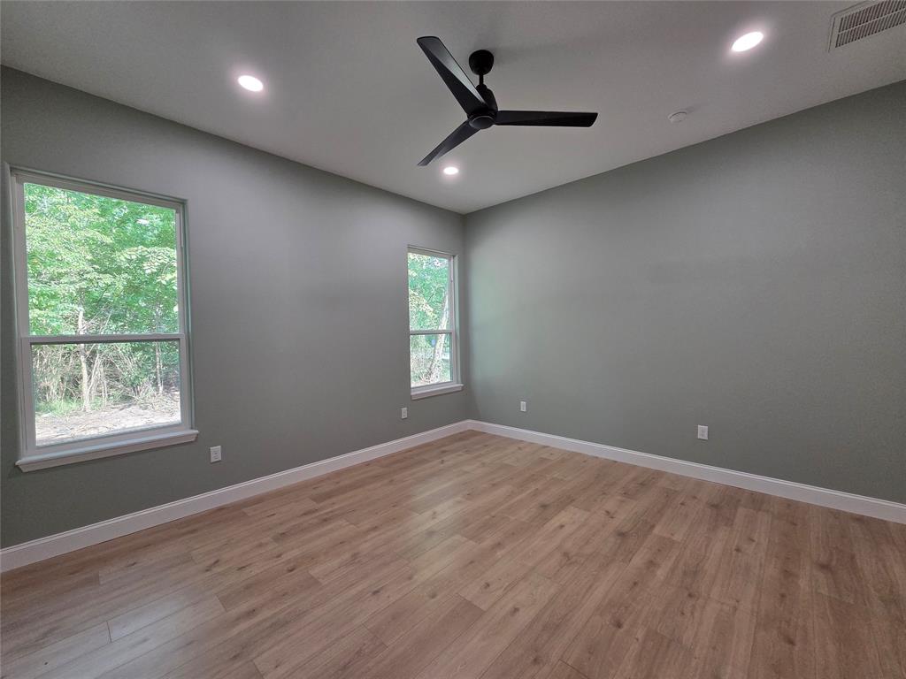 1745 East Cherry Street Paris, TX 75460 - Photo 16 of 40 an empty room with wooden floor and windows