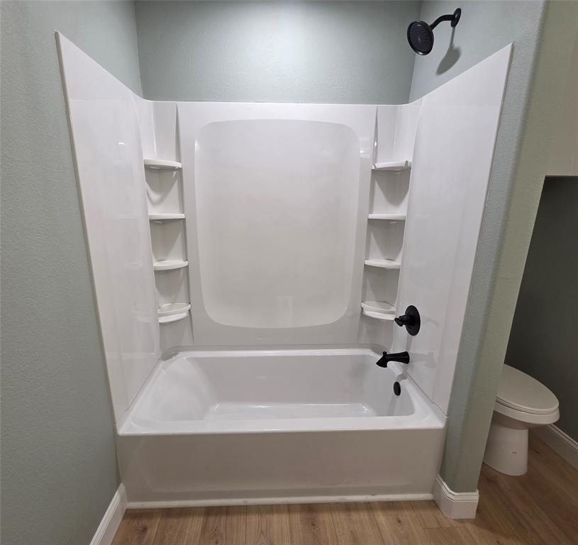 1745 East Cherry Street Paris, TX 75460 - Photo 20 of 40 a bathroom with a bathtub and toilet