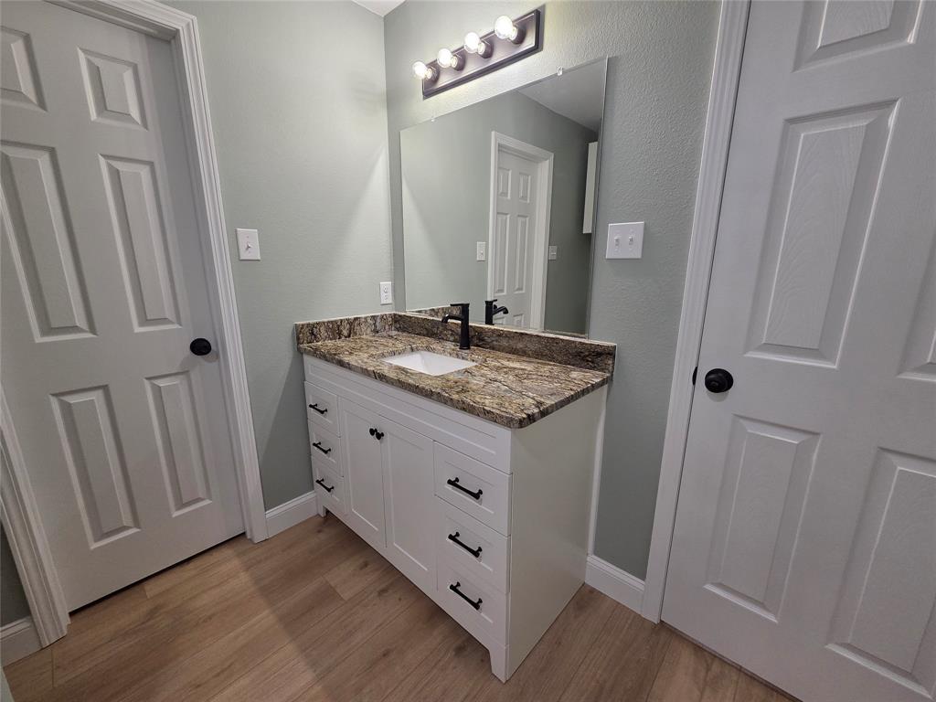 1745 East Cherry Street Paris, TX 75460 - Photo 21 of 40 a bathroom with a granite countertop sink and a mirror