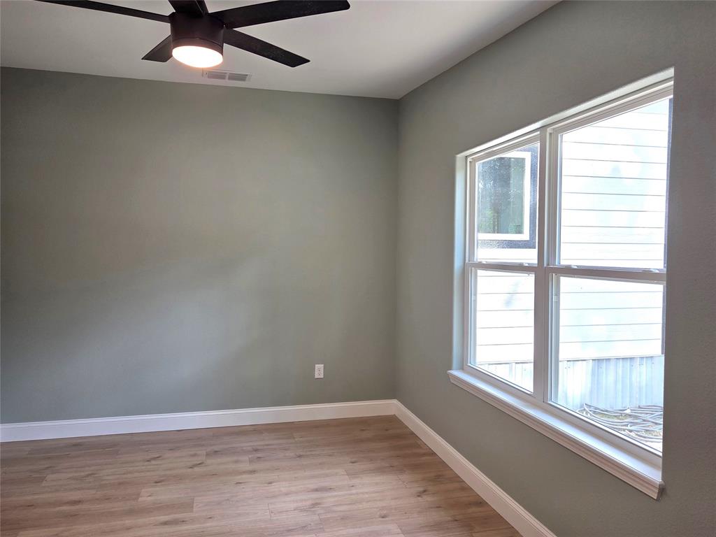 1745 East Cherry Street Paris, TX 75460 - Photo 23 of 40 an empty room with wooden floor and windows