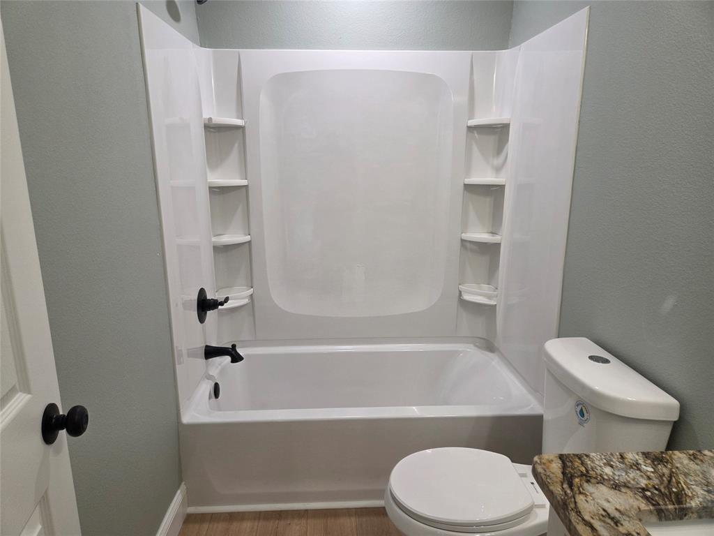 1745 East Cherry Street Paris, TX 75460 - Photo 26 of 40 a bathroom with a toilet and a bathtub