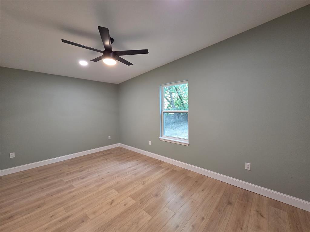1745 East Cherry Street Paris, TX 75460 - Photo 28 of 40 an empty room with wooden floor and windows