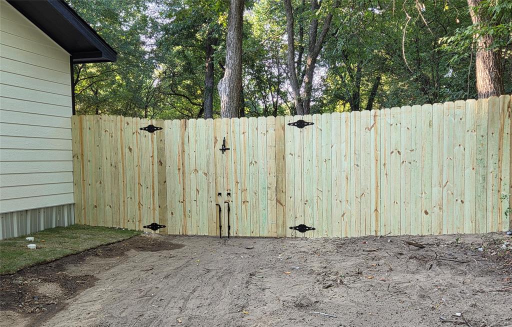 1745 East Cherry Street Paris, TX 75460 - Photo 34 of 40 a view of a house with a wooden fence