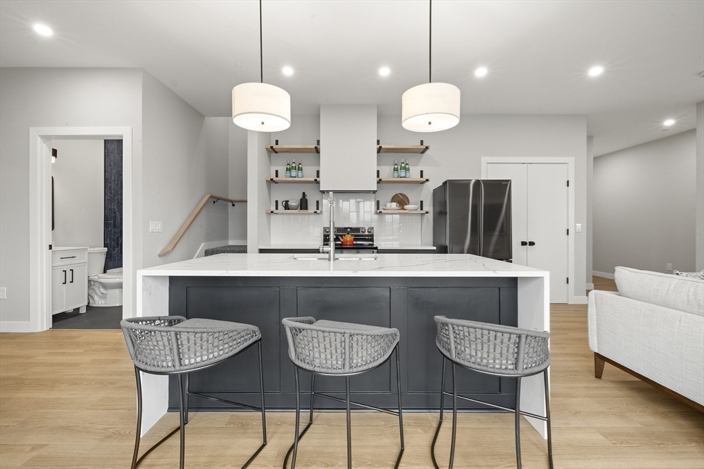 a kitchen with stainless steel appliances granite countertop a table chairs and a chandelier