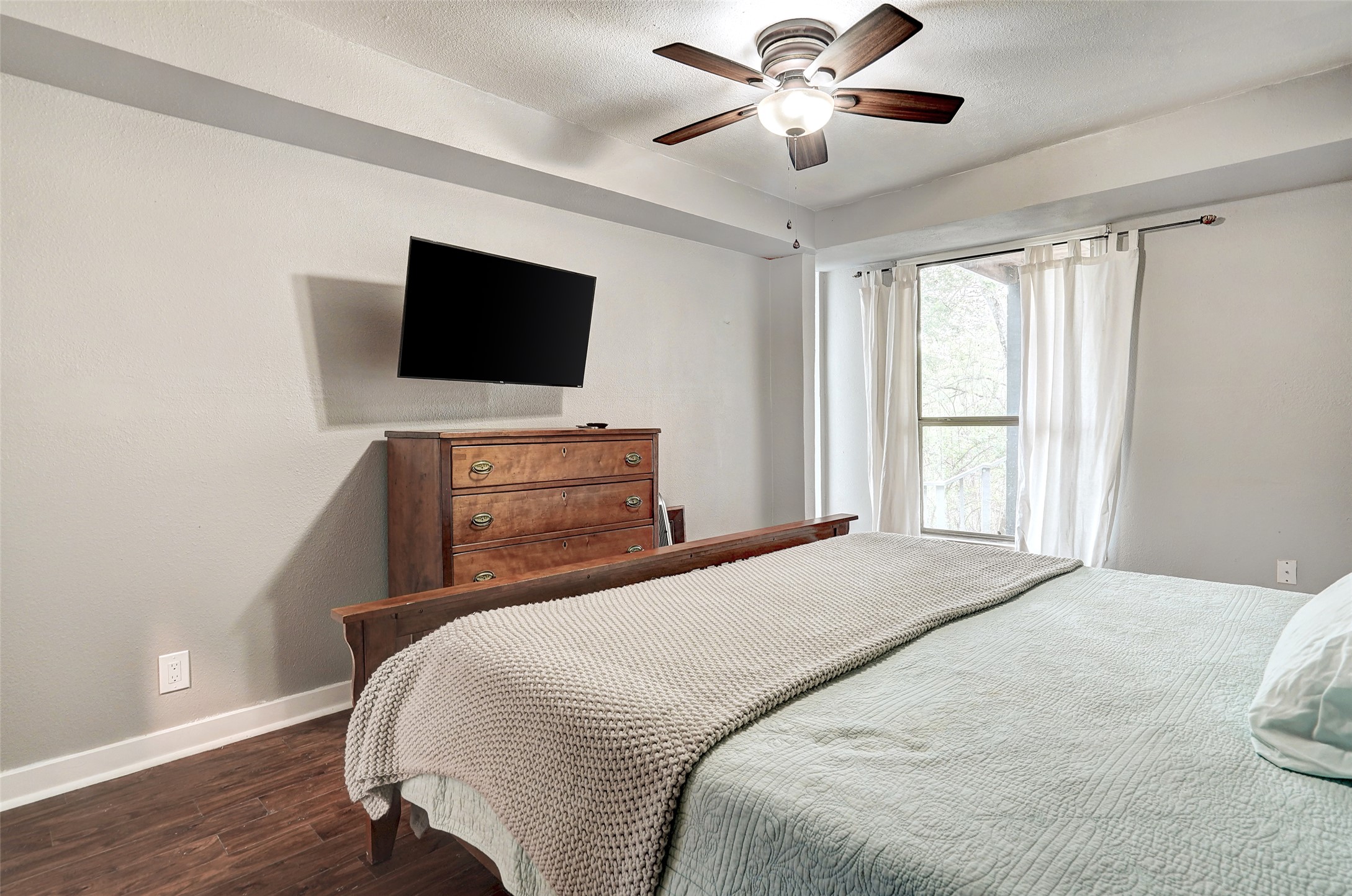 8804 Mountain Ridge Drive, Unit B Austin, TX 78759 - Photo 12 of 17 Relax in this well-lit bedroom featuring a ceiling fan and hardwood flooring.
