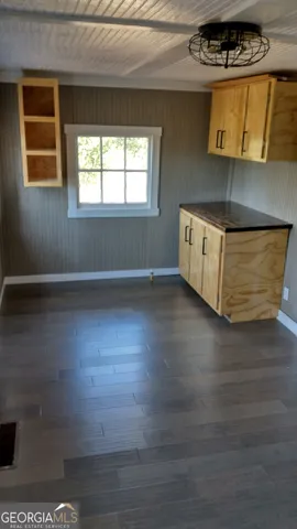 a kitchen with stainless steel appliances granite countertop a refrigerator a sink and a stove with wooden floor