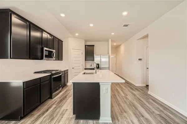 a kitchen with stainless steel appliances granite countertop a sink stove and refrigerator