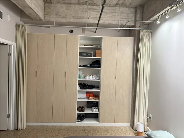 a view of walk in closet with clothes and shoes