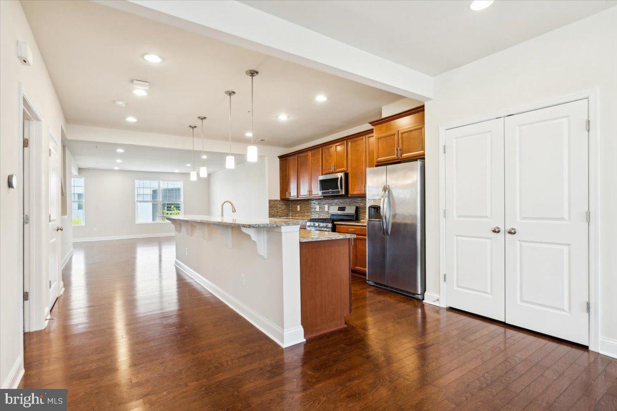 7142 Proclamation Place Frederick, MD 21703 - Photo 13 of 37 a view of kitchen with refrigerator and wooden floor