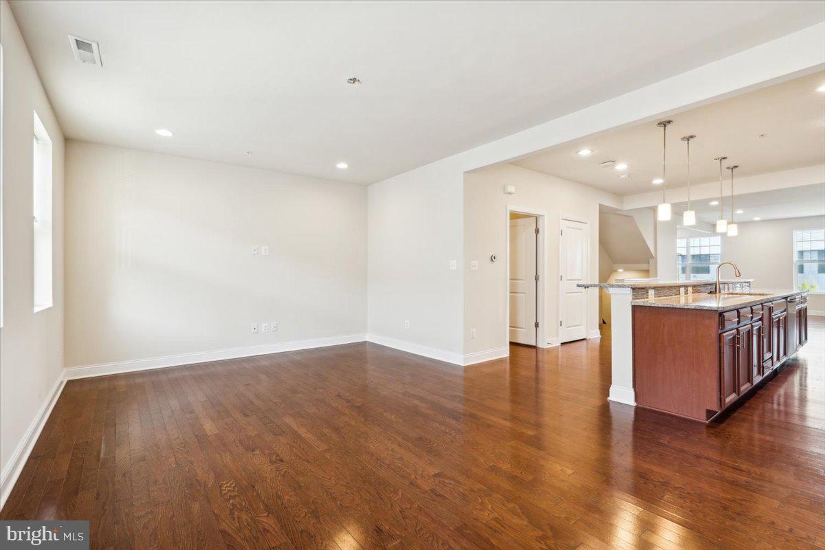 7142 Proclamation Place Frederick, MD 21703 - Photo 17 of 37 a view of kitchen with kitchen island wooden floor center island and stainless steel appliances