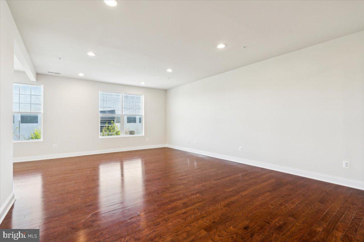 7142 Proclamation Place Frederick, MD 21703 - Photo 19 of 37 an empty room with wooden floor and windows
