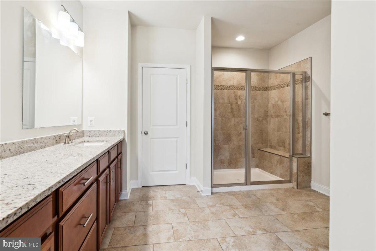 7142 Proclamation Place Frederick, MD 21703 - Photo 25 of 37 a bathroom with a granite countertop sink a mirror and shower