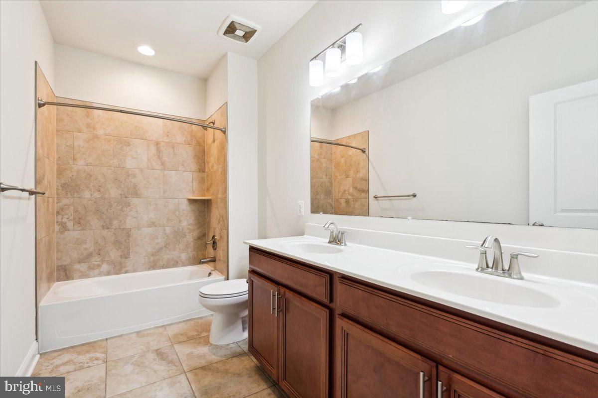 7142 Proclamation Place Frederick, MD 21703 - Photo 26 of 37 a bathroom with a double vanity sink toilet mirror and bathtub