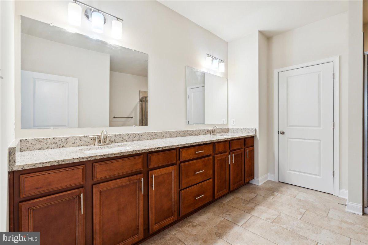 7142 Proclamation Place Frederick, MD 21703 - Photo 31 of 37 a bathroom with double vanity sinks and a large mirror