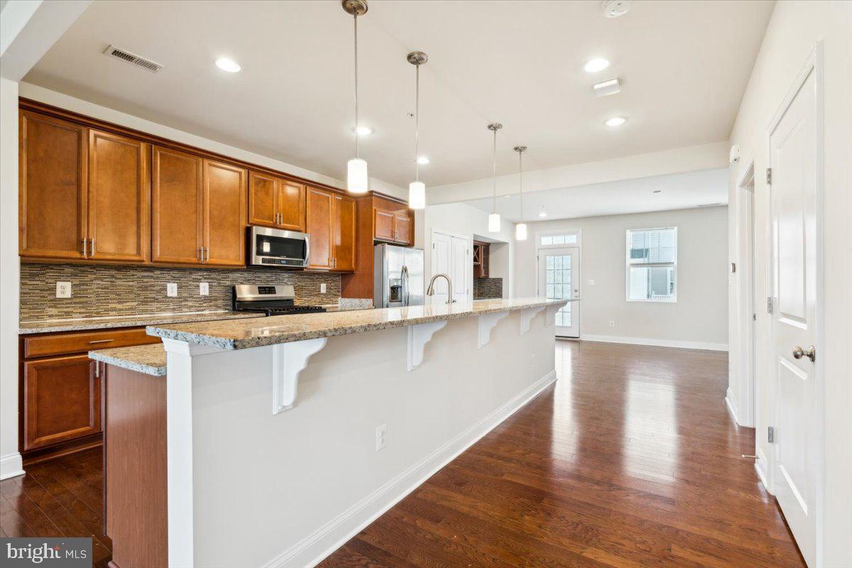 7142 Proclamation Place Frederick, MD 21703 - Photo 8 of 37 a large kitchen with stainless steel appliances granite countertop a stove a sink and a refrigerator