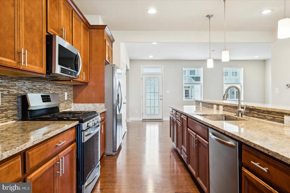 7142 Proclamation Place Frederick, MD 21703 - Photo 9 of 37 a kitchen with stainless steel appliances granite countertop a sink stove and refrigerator