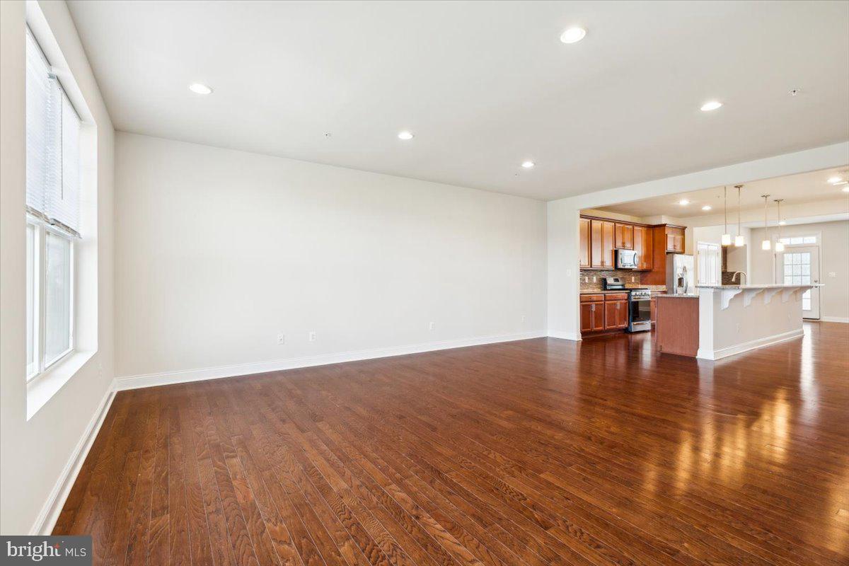 7142 Proclamation Place Frederick, MD 21703 - Photo 10 of 37 a view of an empty room with wooden floor and a window