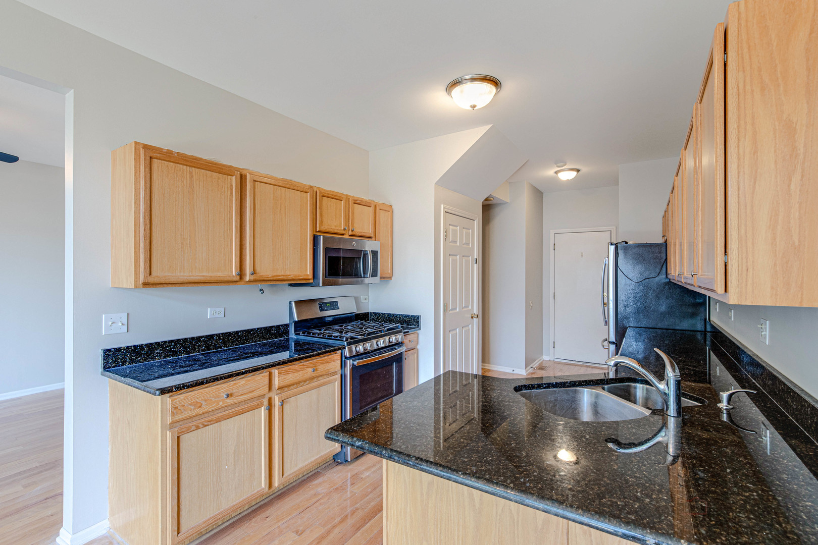 1655 Windward Court Naperville, IL 60563 - Photo 14 of 34 a kitchen with granite countertop a sink a stove and cabinets