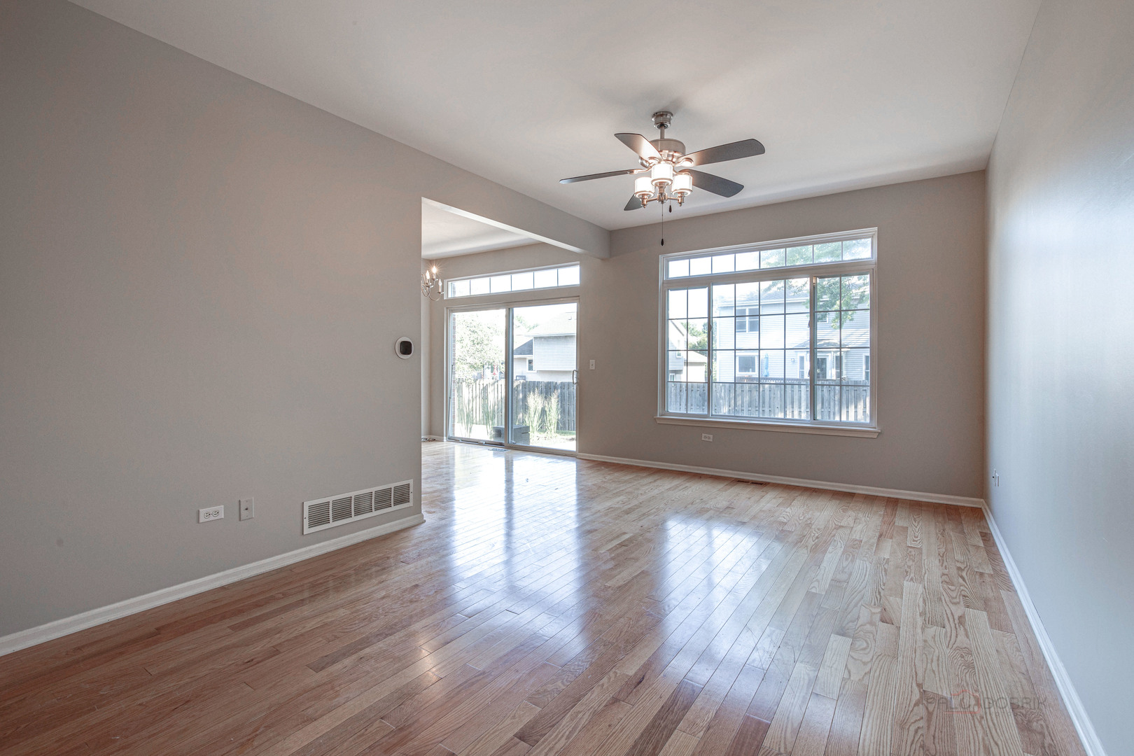 1655 Windward Court Naperville, IL 60563 - Photo 7 of 34 a view of an empty room with wooden floor and a window