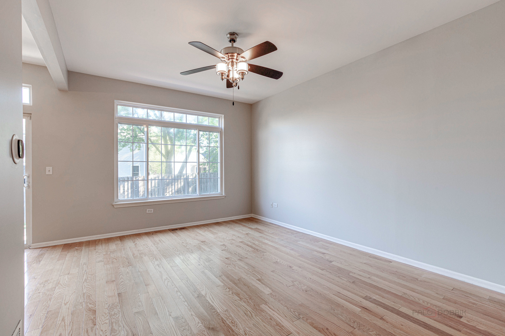 1655 Windward Court Naperville, IL 60563 - Photo 8 of 34 a view of an empty room with wooden floor and a window