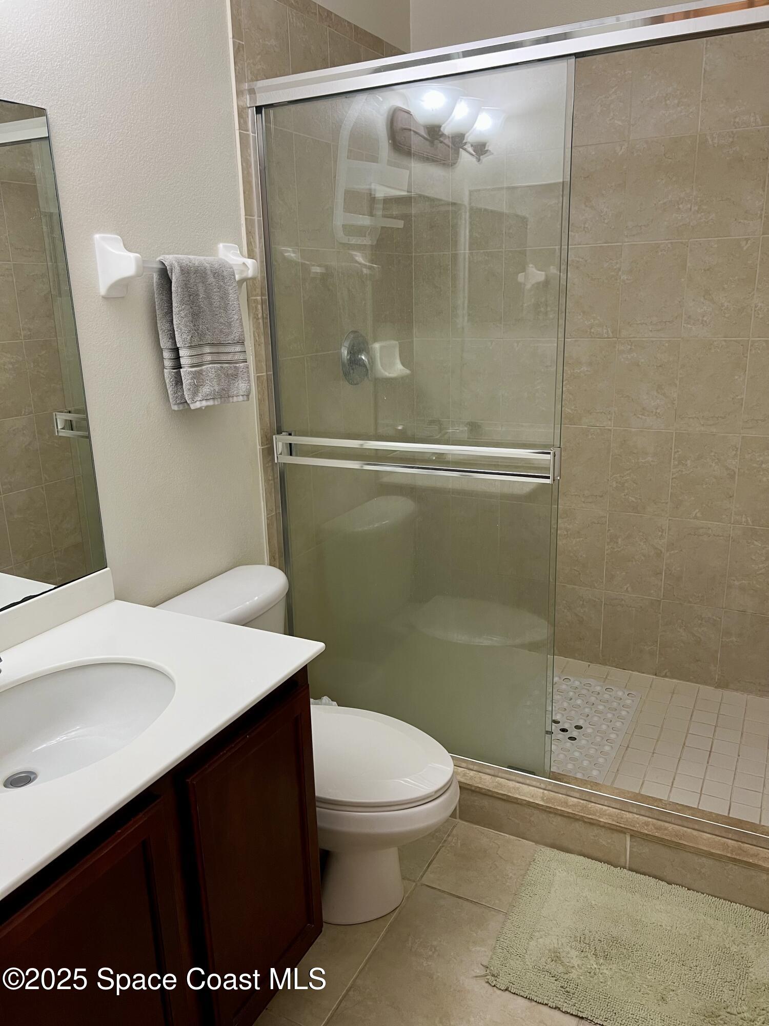 56 Piney Branch Way, Unit A Melbourne, FL 32904 - Photo 11 of 17 a bathroom with a sink a toilet and shower