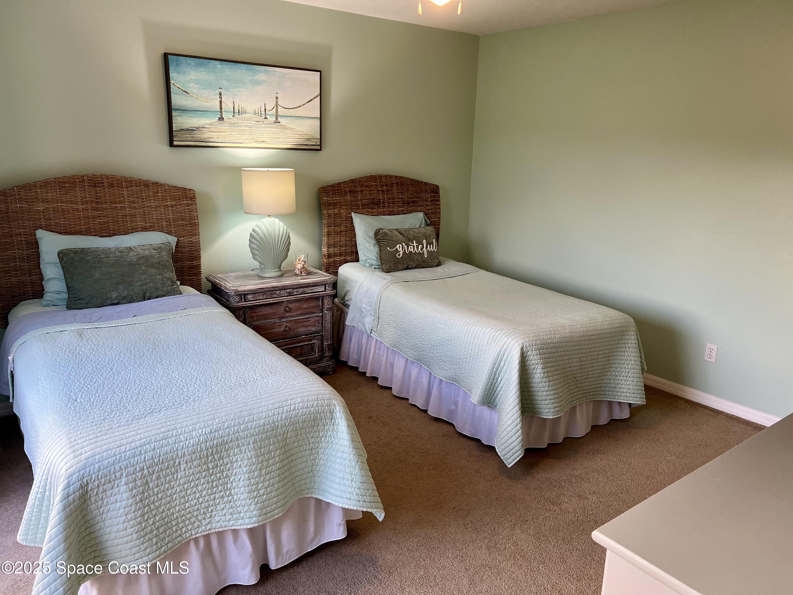 56 Piney Branch Way, Unit A Melbourne, FL 32904 - Photo 13 of 17 a bedroom with two beds and painting on the wall