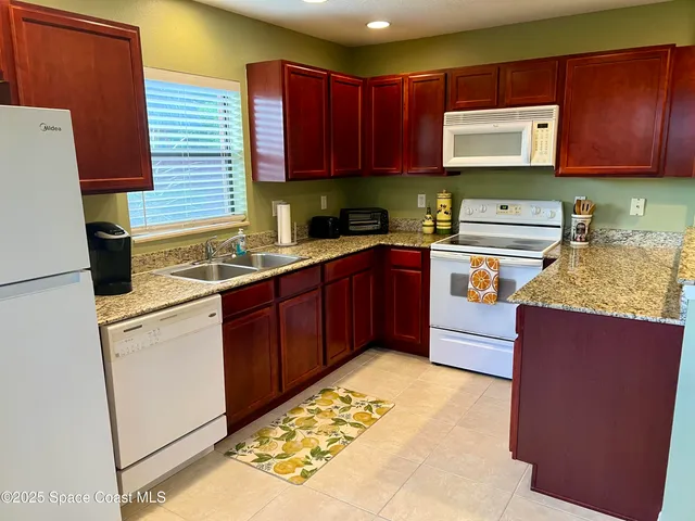 a kitchen with stainless steel appliances granite countertop a refrigerator sink stove and microwave