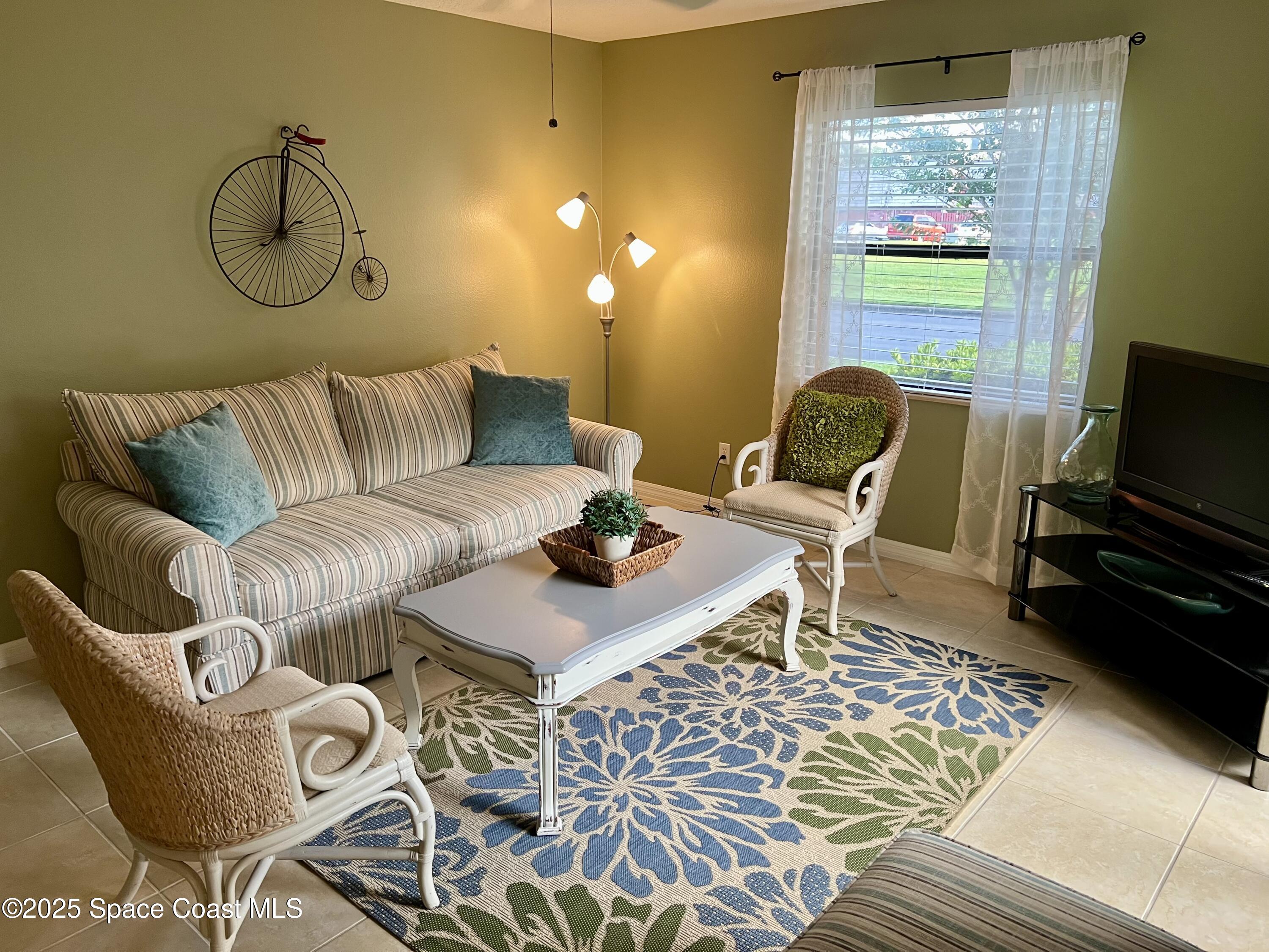 56 Piney Branch Way, Unit A Melbourne, FL 32904 - Photo 8 of 17 a living room with furniture and a flat screen tv