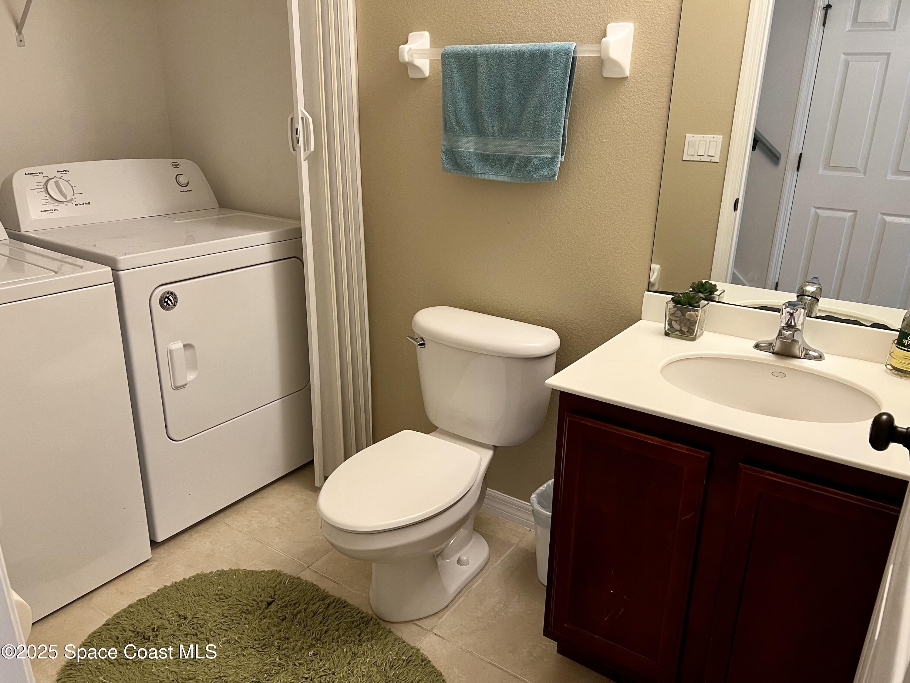56 Piney Branch Way, Unit A Melbourne, FL 32904 - Photo 9 of 17 a bathroom with a sink a toilet and a mirror