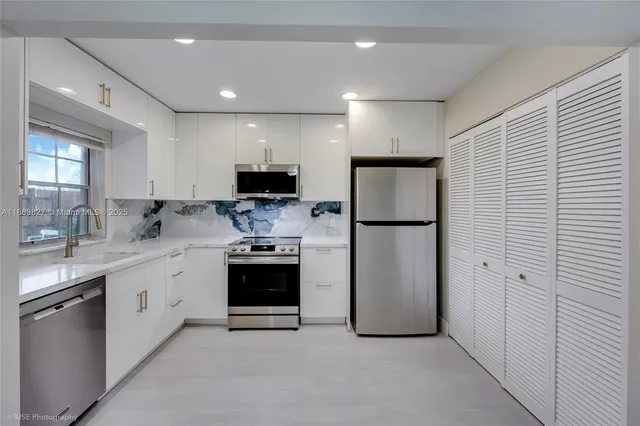 a kitchen with stainless steel appliances a refrigerator sink and microwave