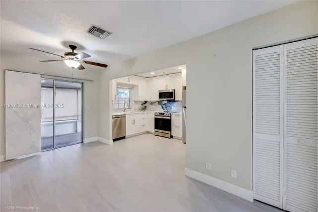 a view of a kitchen with furniture and a ceiling fan