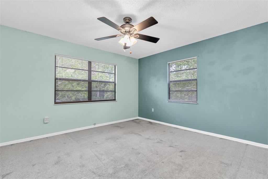 7230 Hummingbird Lane New Port Richey, FL 34655 - Photo 25 of 41 an empty room with ceiling fan and windows