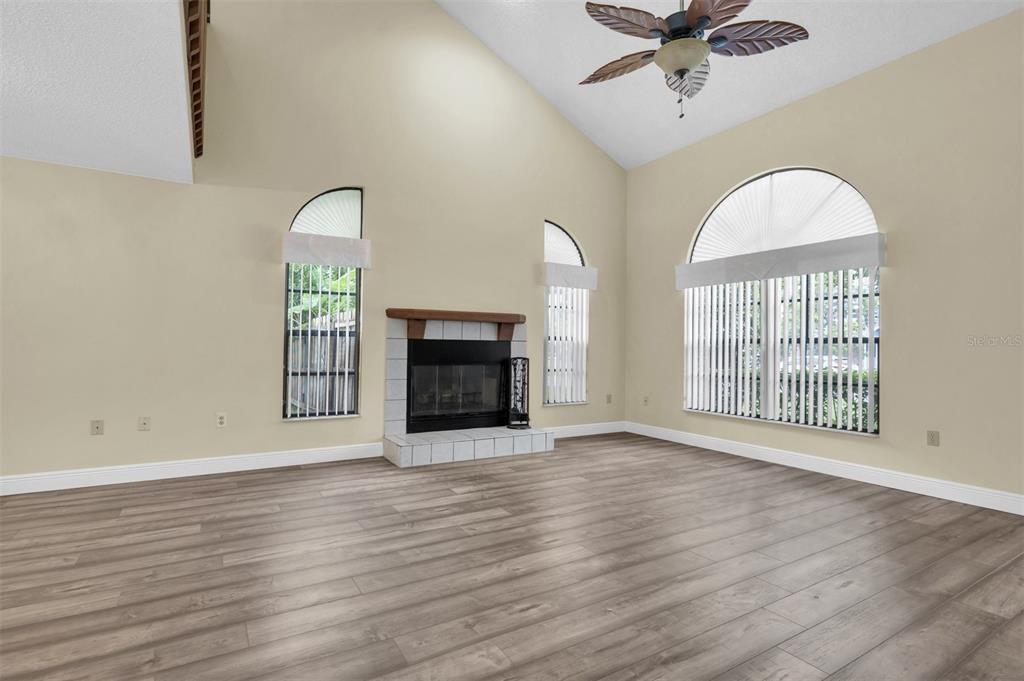 7230 Hummingbird Lane New Port Richey, FL 34655 - Photo 8 of 41 an empty room with wooden floor fan and windows