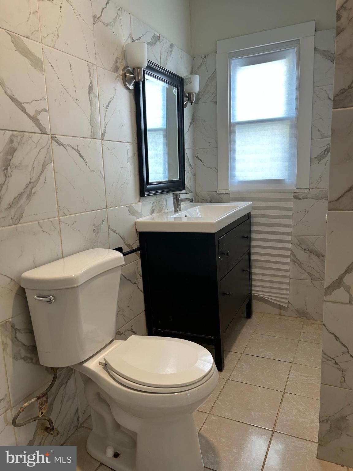 3405 Dennlyn Road Baltimore, MD 21215 - Photo 9 of 20 a bathroom with a toilet a sink and mirror