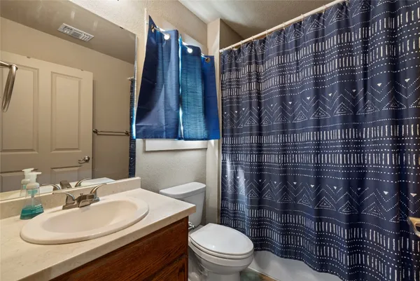 a bathroom with a sink toilet vanity and shower