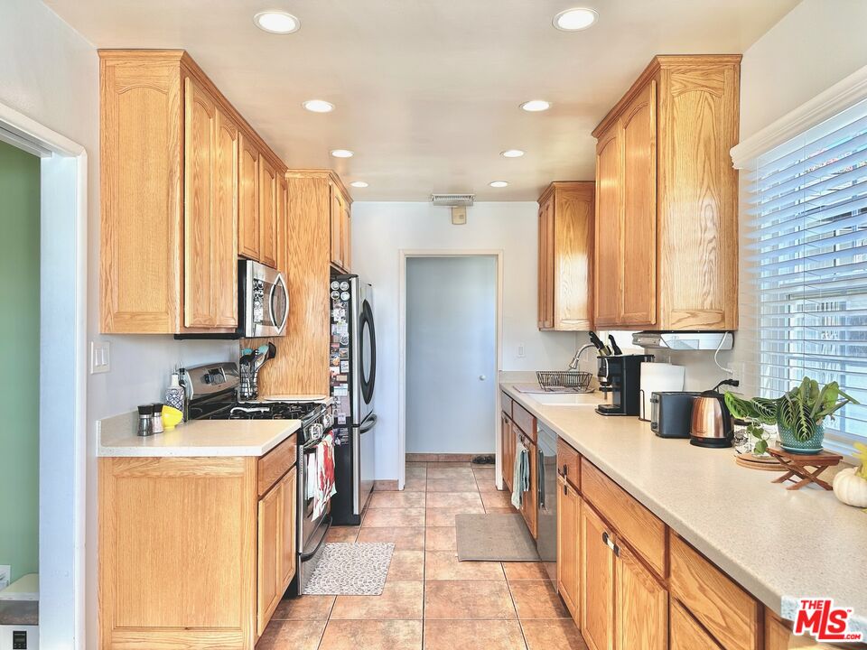2132 Mcpherson Place Los Angeles, CA 90032 - Photo 10 of 28 a kitchen with stainless steel appliances a sink stove and cabinets