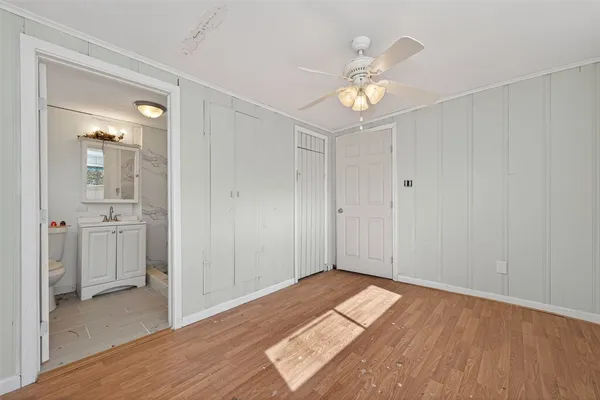 a view of a room with wooden floor and a ceiling fan