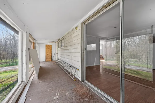 a view of a hallway with a large window and wooden floor