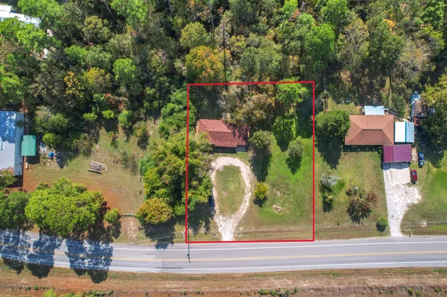 a view of a yard in front of a house with large trees