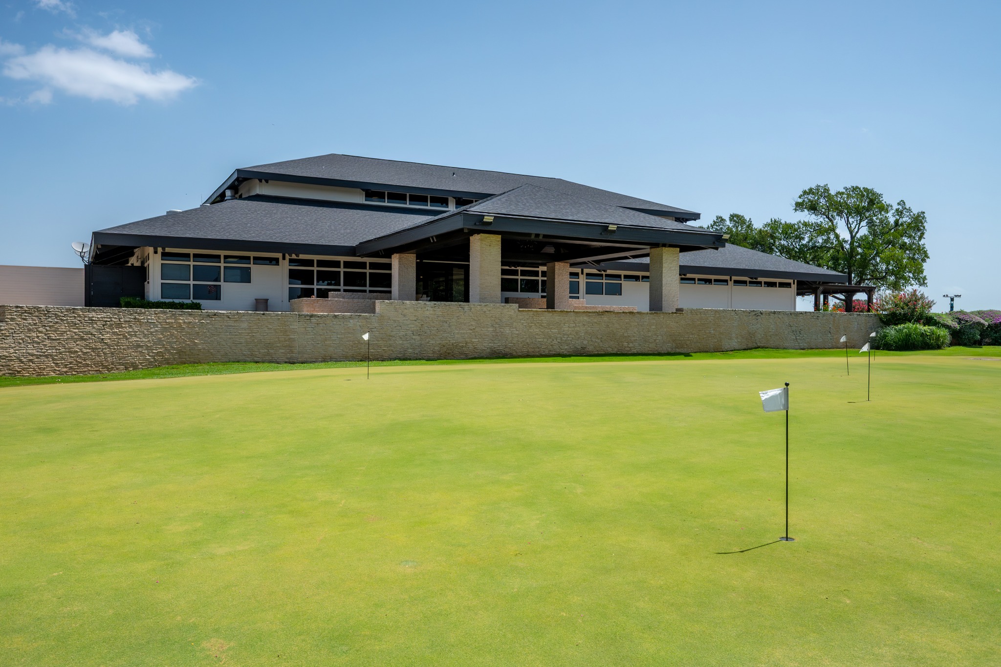 30115 Sawgrass Trail Georgetown, TX 78628 - Photo 30 of 37 A well-maintained putting green fronts a striking clubhouse with a distinctive, dark-roofed architecture.