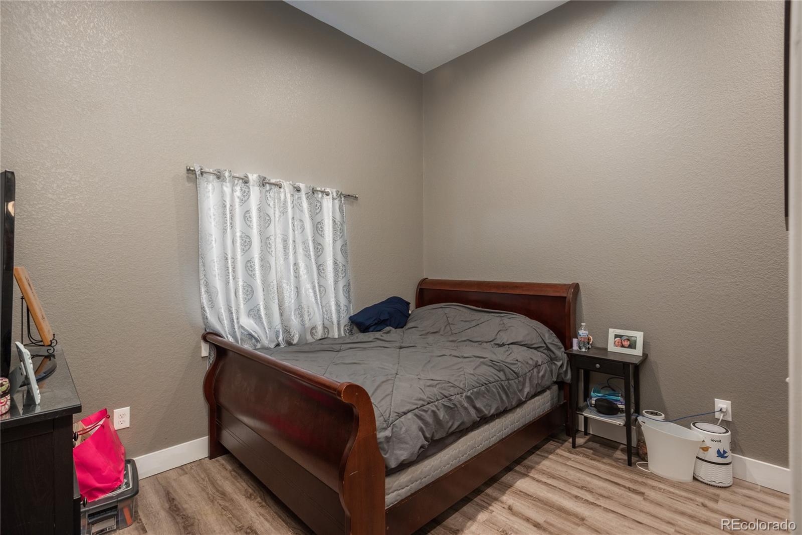 854 Russellville Road Franktown, CO 80116 - Photo 29 of 35 a bedroom with a bed and wooden floor