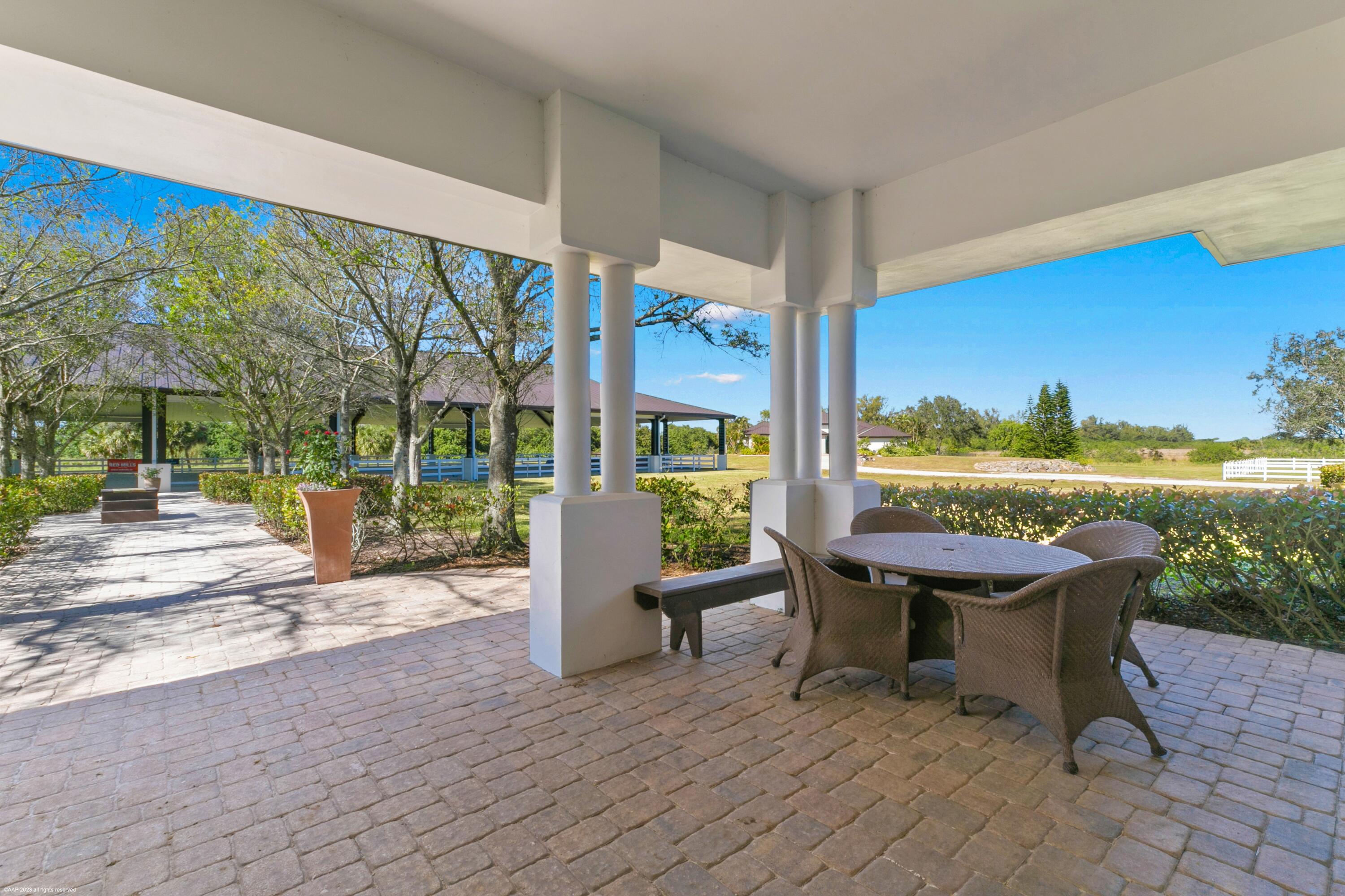 3790 Hanover Circle Loxahatchee, FL 33470 - Photo 25 of 73 a view of a patio with a table chairs and a floor to ceiling window