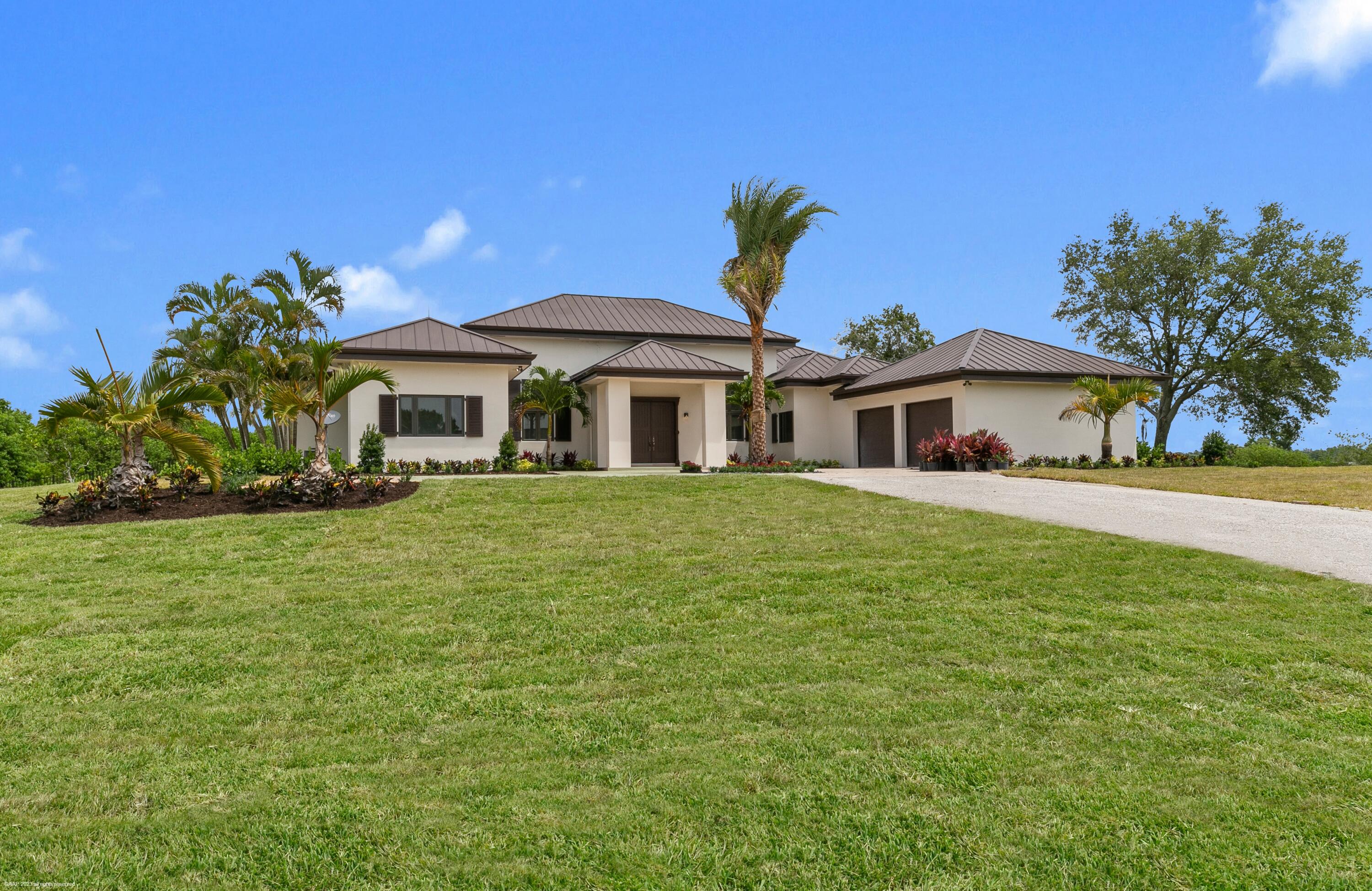 3790 Hanover Circle Loxahatchee, FL 33470 - Photo 43 of 73 a front view of a house with a garden