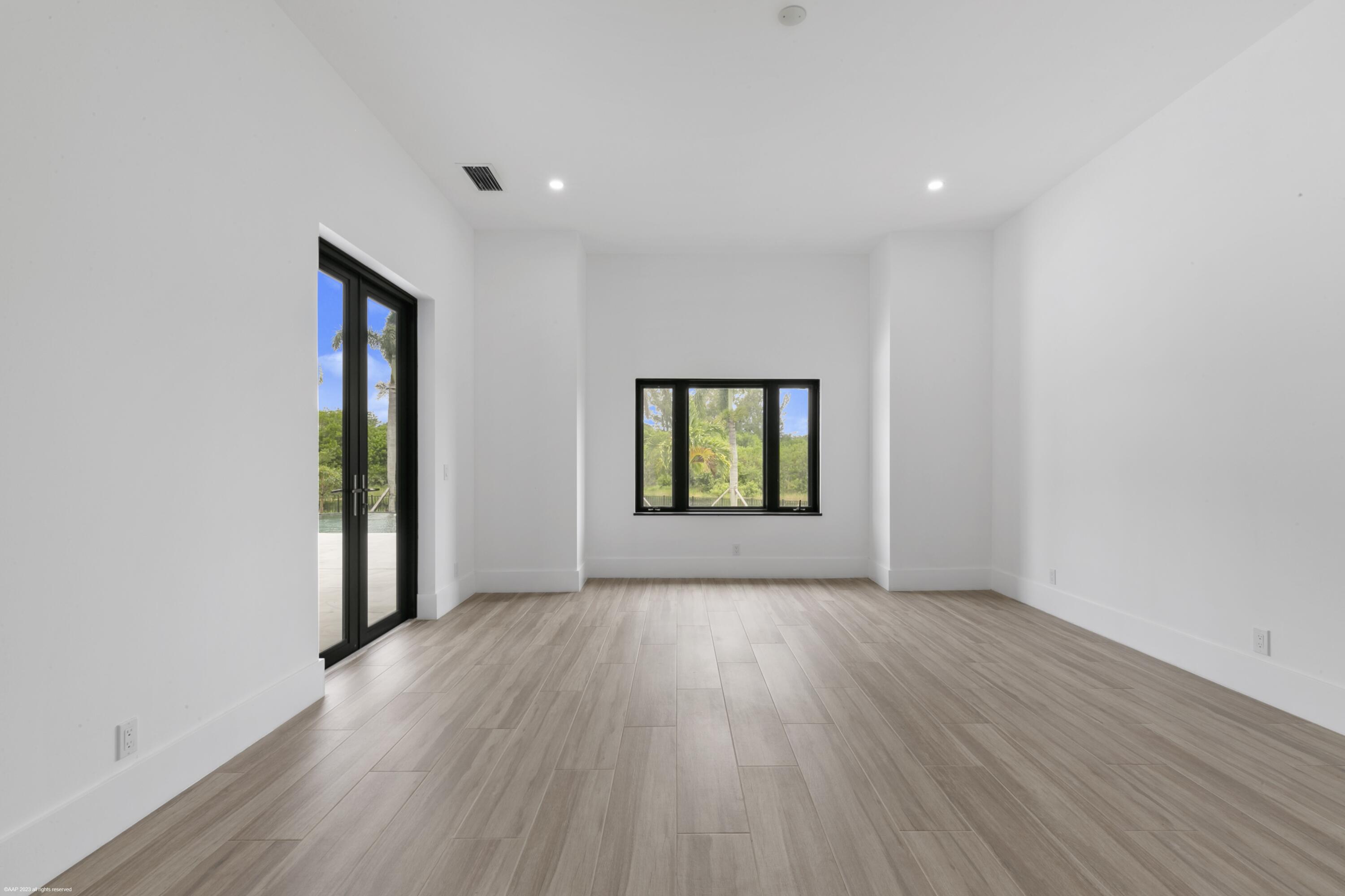 3790 Hanover Circle Loxahatchee, FL 33470 - Photo 56 of 73 an empty room with wooden floor and windows