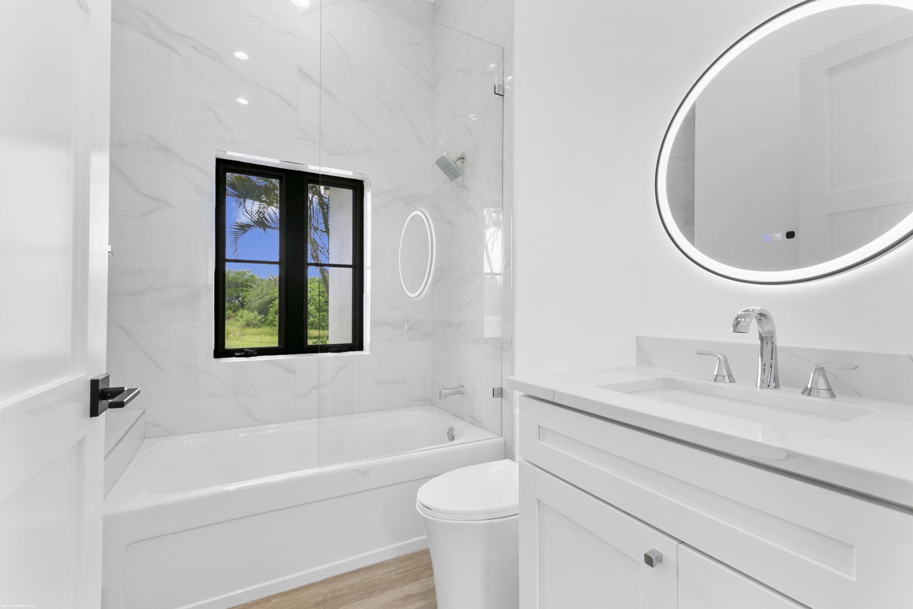 3790 Hanover Circle Loxahatchee, FL 33470 - Photo 62 of 73 a bathroom with a toilet a sink and a bathtub