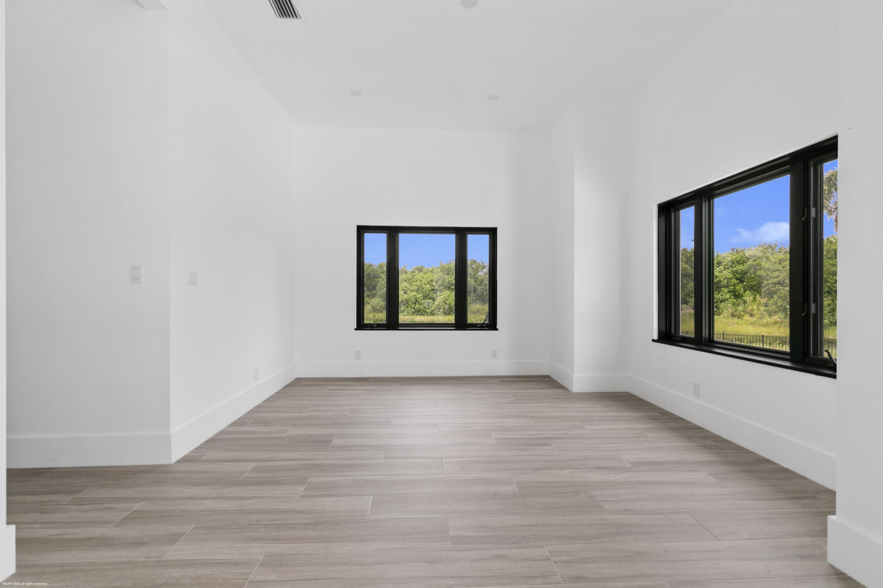 3790 Hanover Circle Loxahatchee, FL 33470 - Photo 71 of 73 a view of an empty room with wooden floor and a window